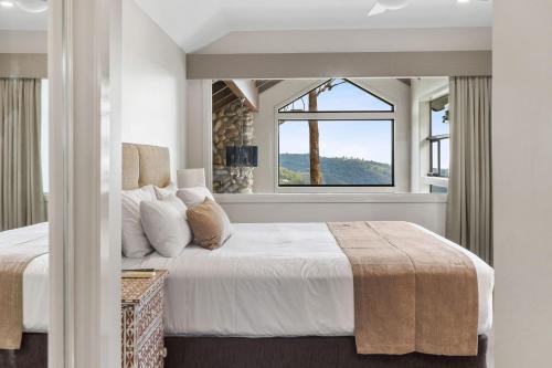 ein Schlafzimmer mit einem großen Bett und einem Fenster in der Unterkunft Edges by St Bernards Hotel in Mount Tamborine