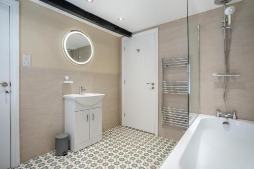 a bathroom with a tub and a sink and a mirror at 3 Bed in Reeth oc-l32438 in Reeth