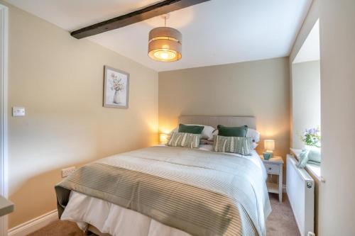 a bedroom with a large bed with green pillows at 3 Bed in Reeth oc-l32438 in Reeth