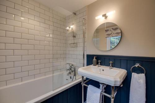 a bathroom with a sink and a tub and a mirror at 3 Bed in Fowey oc-p00871 in Fowey