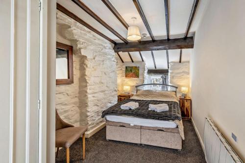 a bedroom with a bed and a chair in a room at 3 Bed in Fucheswen oc-c29607 in Blaenau-Ffestiniog