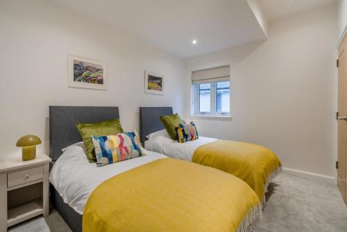 two beds in a room with yellow and white at 3 Bed in Fearnan oc-s29984 in Chesthill