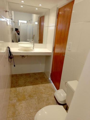 a bathroom with a white toilet and a sink at Hostal La Candelaria in Humahuaca