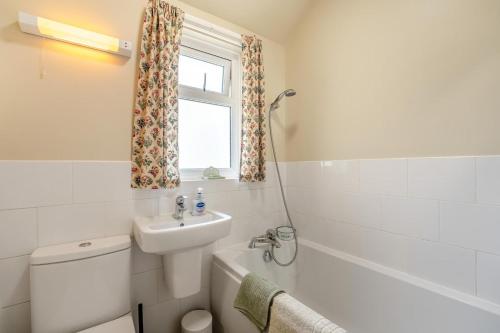 a bathroom with a sink and a toilet and a window at 2 Bed in Dymchurch oc-s31998 in Dymchurch