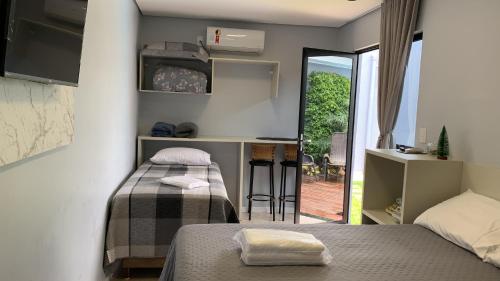 a room with two beds and a kitchen with a balcony at Pousada Selenita in Ametista do Sul