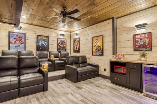 a movie room with leather chairs and a tv at Firefly Lodge - Pool, Theatre, Dog Friendly! in Pigeon Forge