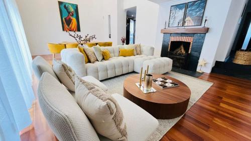 a living room with white furniture and a fireplace at Villa Pinheirinhos - Enjoy the Nature & Wild Beaches of Sesimbra! in Sesimbra