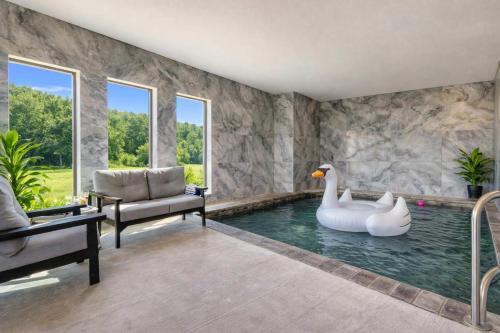 a swimming pool with two swans in a room at Firefly Lodge - Pool, Theatre, Dog Friendly! in Pigeon Forge