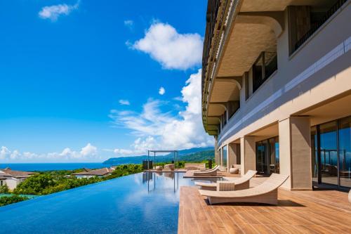 an infinity pool in a building with a view of the ocean at KAMENOI HOTEL Izukogen in Ito