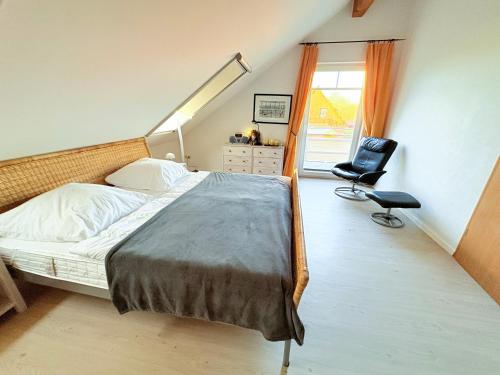 a bedroom with a bed and a chair and a window at Ferienhaus Carlo - renoviert 2025, top Lage, hundefreundlich in Glowe