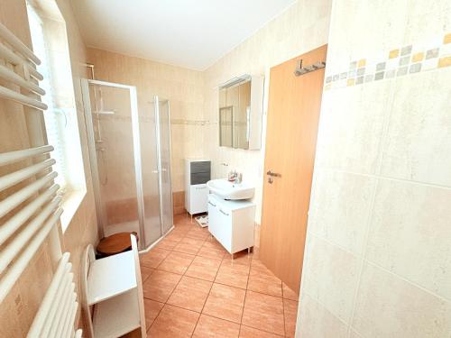 a bathroom with a shower and a sink and a toilet at Ferienhaus Carlo - renoviert 2025, top Lage, hundefreundlich in Glowe