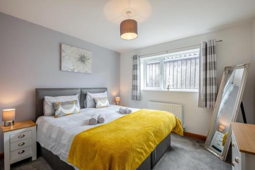 a bedroom with a large bed with a yellow blanket at 2 Bed in Pickering oc-d32743 in Pickering