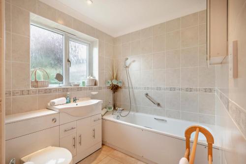 a bathroom with a tub and a sink and a bath tub at 3 Bed in Thornham oc-m28084 in Thornham