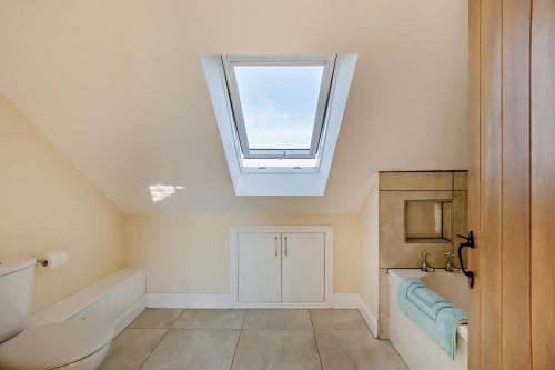a bathroom with a skylight and a toilet and a sink at 2 Bed in Feering oc-p29293 in Feering
