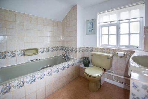 a bathroom with a toilet and a tub and a sink at 2 Bed in Porthleven oc-stmich in Porthleven