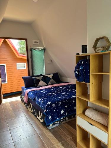 a bedroom with a bed with a blue comforter at Thanya campsite Thailand in Ban Thai Thai