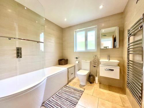 a bathroom with a tub and a toilet and a sink at 2 Bed in Witheridge oc-b29206 in Witheridge
