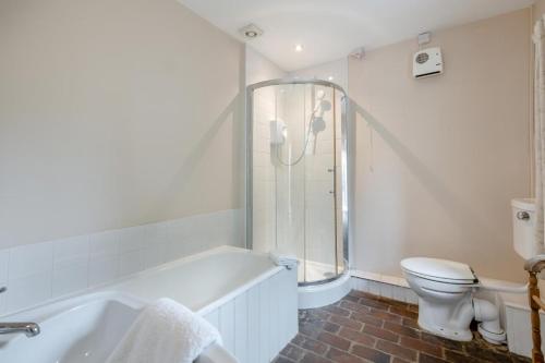 a white bathroom with a tub and a toilet at 2 Bed in Burnham Overy Staithe oc-p30460 in Burnham Market