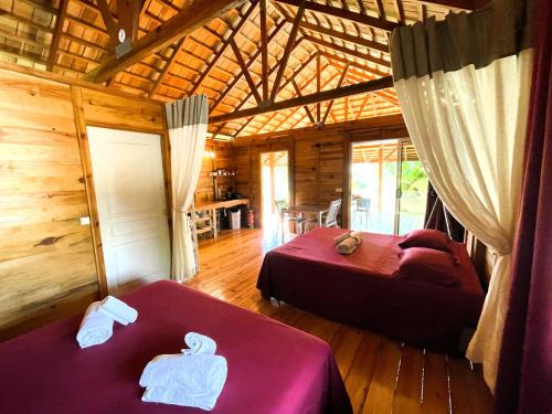 a bedroom with two beds in a wooden house at RAIATEA - Orion Pool Bungalow in Uturoa
