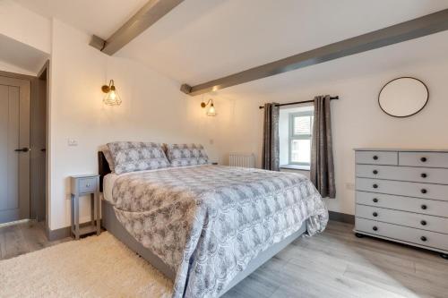 a bedroom with a bed and a dresser and a window at 3 Bed in Burtersett oc-ds1043 in Hawes