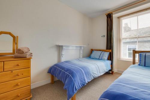 a bedroom with two beds and a dresser and a window at 2 Bed in Mousehole oc-mizpah in Mousehole