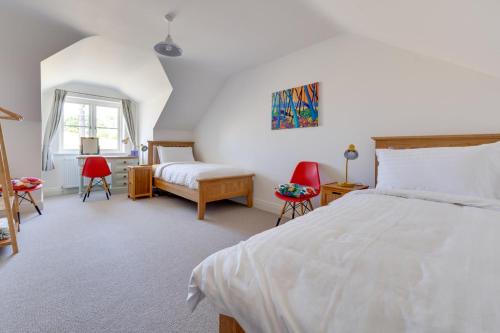 a bedroom with a large white bed and red chairs at 3 Bed in Chatton oc-nb1987 in Chatton