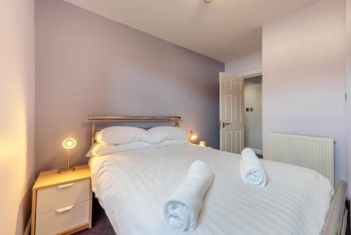 a bedroom with a large white bed with towels on it at 2 Bed in Tenby oc-w28987 in Tenby