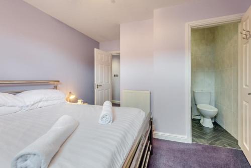 a bedroom with a white bed and a toilet at 2 Bed in Tenby oc-w28987 in Tenby