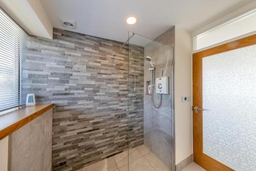 a bathroom with a shower with a stone wall at 2 Bed in Aberdovey oc-n30627 in Aberdyfi