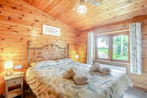 a bedroom with a bed in a wooden cabin at 2 Bed in Otley oc-slm in Burgh