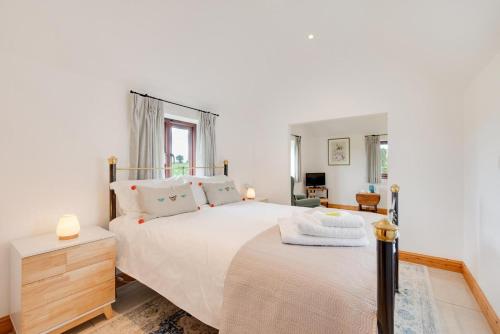 a bedroom with a large white bed and a desk at 1 Bed in Mautby oc-2302 in Mautby