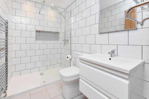 a white bathroom with a toilet and a sink at 2 Bed in Bwlchtocyn oc-thetac in Abersoch