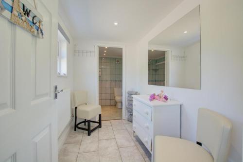 a bathroom with a white dresser and a mirror at 4 Bed in Wiggenhall St. Germans oc-2011 in King's Lynn