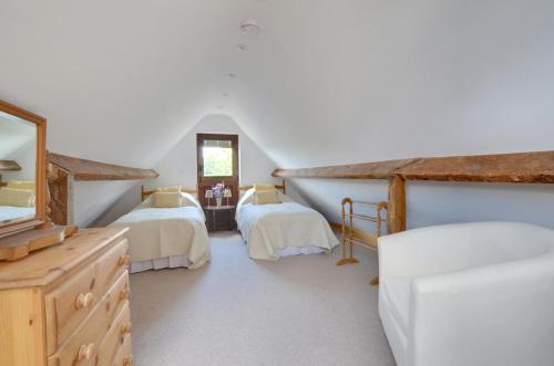 a attic bedroom with two beds and a mirror at 3 Bed in Wadhurst oc-tw665 in Wadhurst