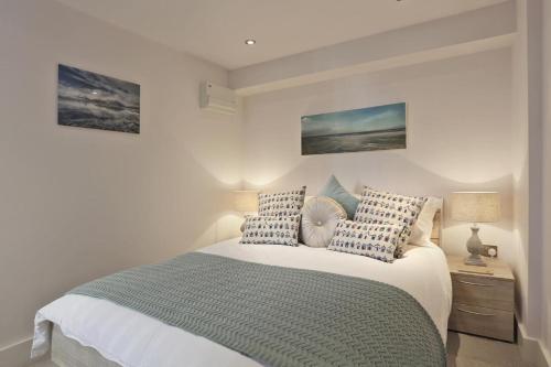 a bedroom with a bed with blue and white pillows at 2 Bed in Southwold oc-wtp in Southwold