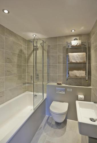 a bathroom with a toilet and a tub and a sink at 2 Bed in Southwold oc-wtp in Southwold