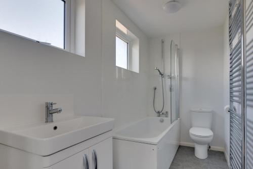a white bathroom with a sink and a toilet at 3 Bed in Aldeburgh oc-10nw in Aldeburgh