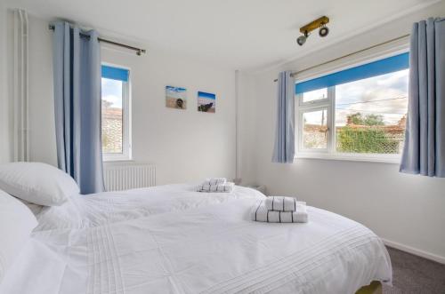 ein weißes Schlafzimmer mit zwei Betten und einem Fenster in der Unterkunft 2 Bed in Docking oc-2212 in Docking