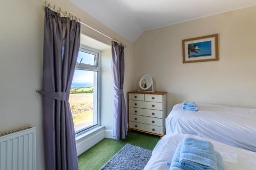 a bedroom with a bed and a window at 4 Bed in Bwlchtocyn oc-uchaf in Abersoch