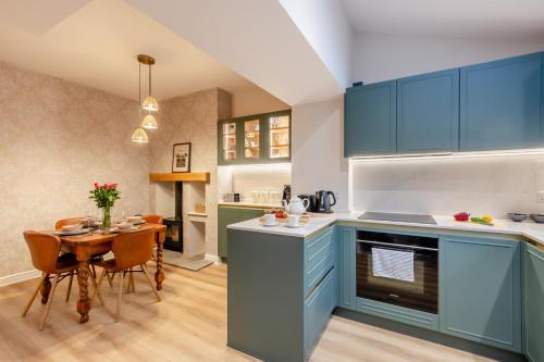a kitchen with blue cabinets and a table with chairs at 3 Bed in Ilkley oc-i30726 in Ilkley