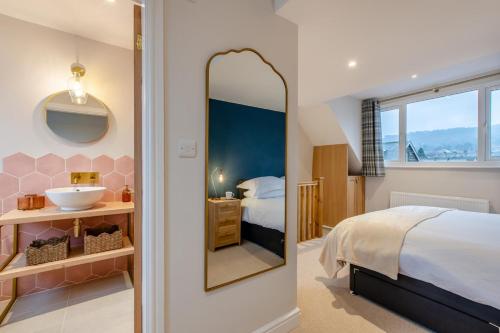 a bedroom with a bed and a sink and a mirror at 3 Bed in Ilkley oc-i30726 in Ilkley