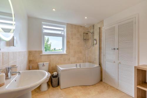 a white bathroom with a tub and a sink at 5 Bed in Bodmin oc-l29658 in Blisland