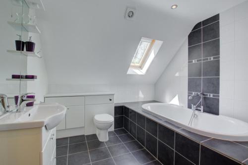 ein Badezimmer mit Waschbecken, Badewanne und Toilette in der Unterkunft 3 Bed in Fakenham oc-1315 in Thursford