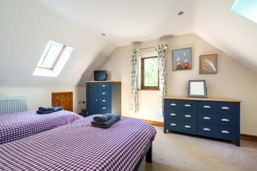 ein Dachgeschoss-Schlafzimmer mit zwei Betten und einer Kommode in der Unterkunft 3 Bed in Fakenham oc-1315 in Thursford
