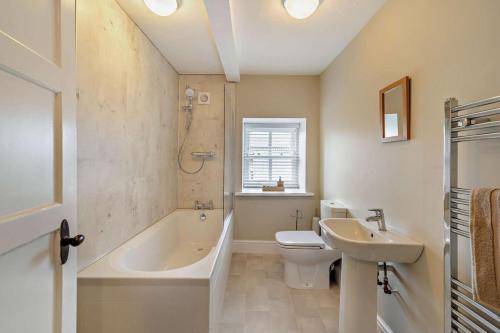 a bathroom with a tub and a toilet and a sink at 4 Bed in Kinniside oc-c28854 in Frizington