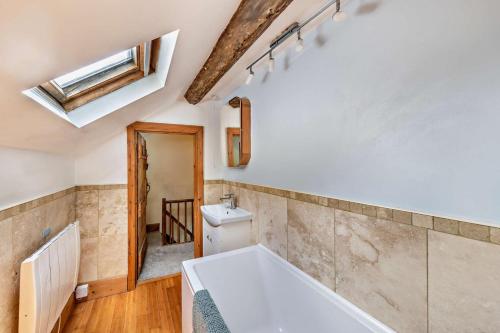 a bathroom with a bath tub and a sink at 3 Bed in Fucheswen oc-m29608 in Blaenau-Ffestiniog