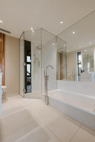 a large white bathroom with a tub and a shower at Peak View Retreat in Nelson