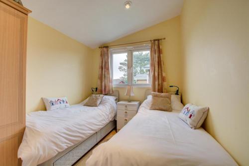 two twin beds in a room with a window at 2 Bed in St. Merryn oc-p00673 in Saint Merryn