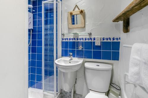 a blue and white bathroom with a toilet and a sink at 1 Bed in Porthleven oc-smuggl in Porthleven