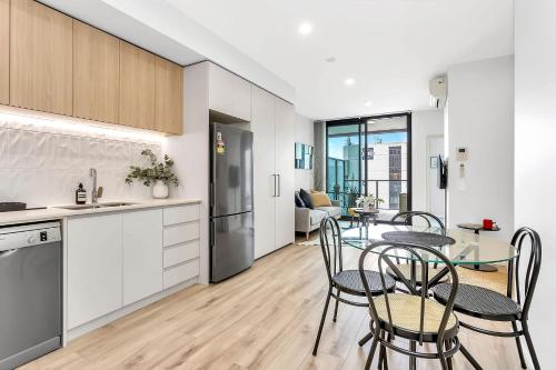 a kitchen and dining room with a table and chairs at Level 18 Heart of Adelaide with Gym, City Views in Adelaide